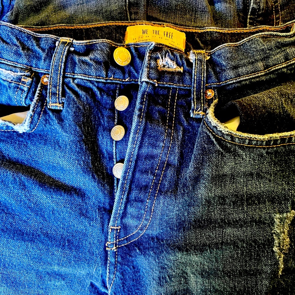 We The Free jeans. Size 25. Button front. Torn knee. Tapered frayed leg.